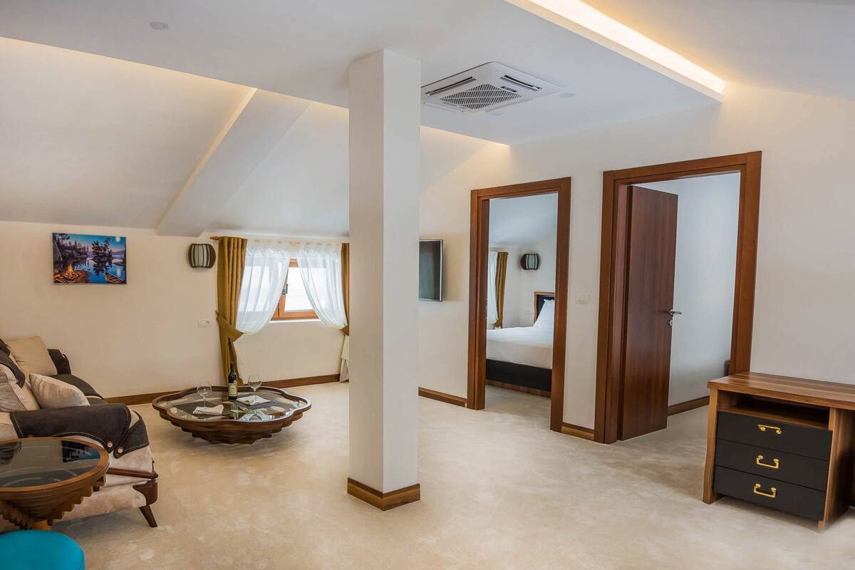 A well-lit room with a sofa, a coffee table, a TV, and a wooden cabinet.