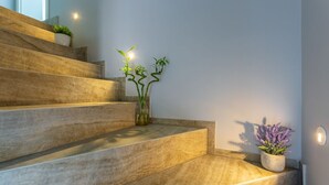 A staircase with a modern design, featuring a light-colored stone finish and a small potted plant on the landing. - Apartment in Njivice with Seaview, Balcony, Air condition, WIFI (4930-1) (Njivice)