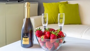 A bottle of Canella Prosecco champagne, two glasses, and a bowl of strawberries on a table. - Apartment in Njivice with Seaview, Balcony, Air condition, WIFI (4930-2) (Njivice)