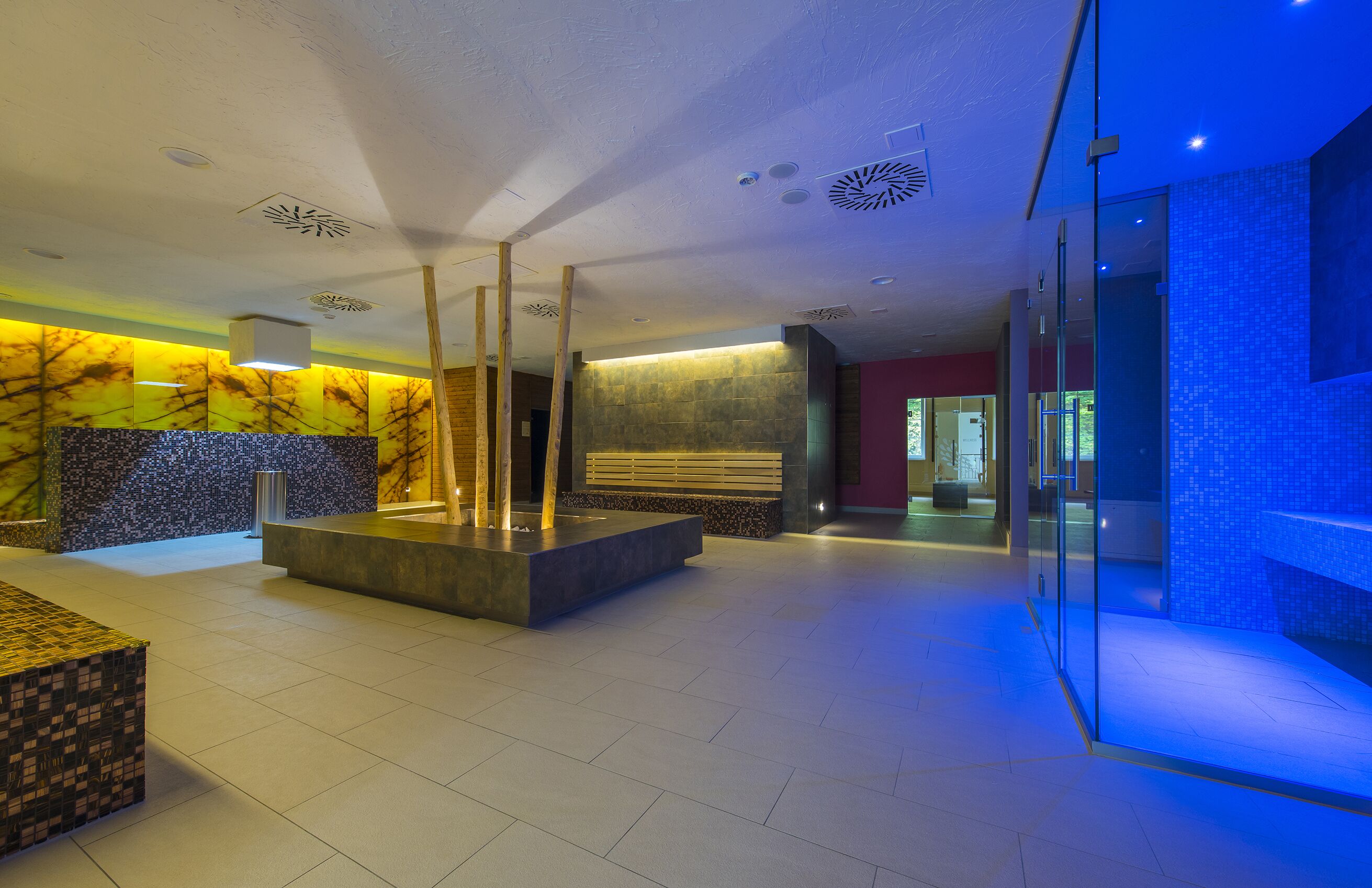 Eine moderne Lobby mit Marmorwand, einer Rezeption und einer Sitzecke.