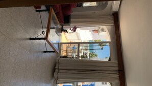 A room with a large window, a ceiling fan, and a view of the outside. - Casa Playa El Torreon (La cala de mijas)
