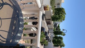A street view with a white building, a parked bicycle, and a clear blue sky. - Casa Playa El Torreon (La cala de mijas)