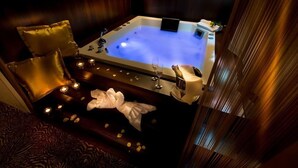 Un jacuzzi con velas, una toalla y un vaso de agua.