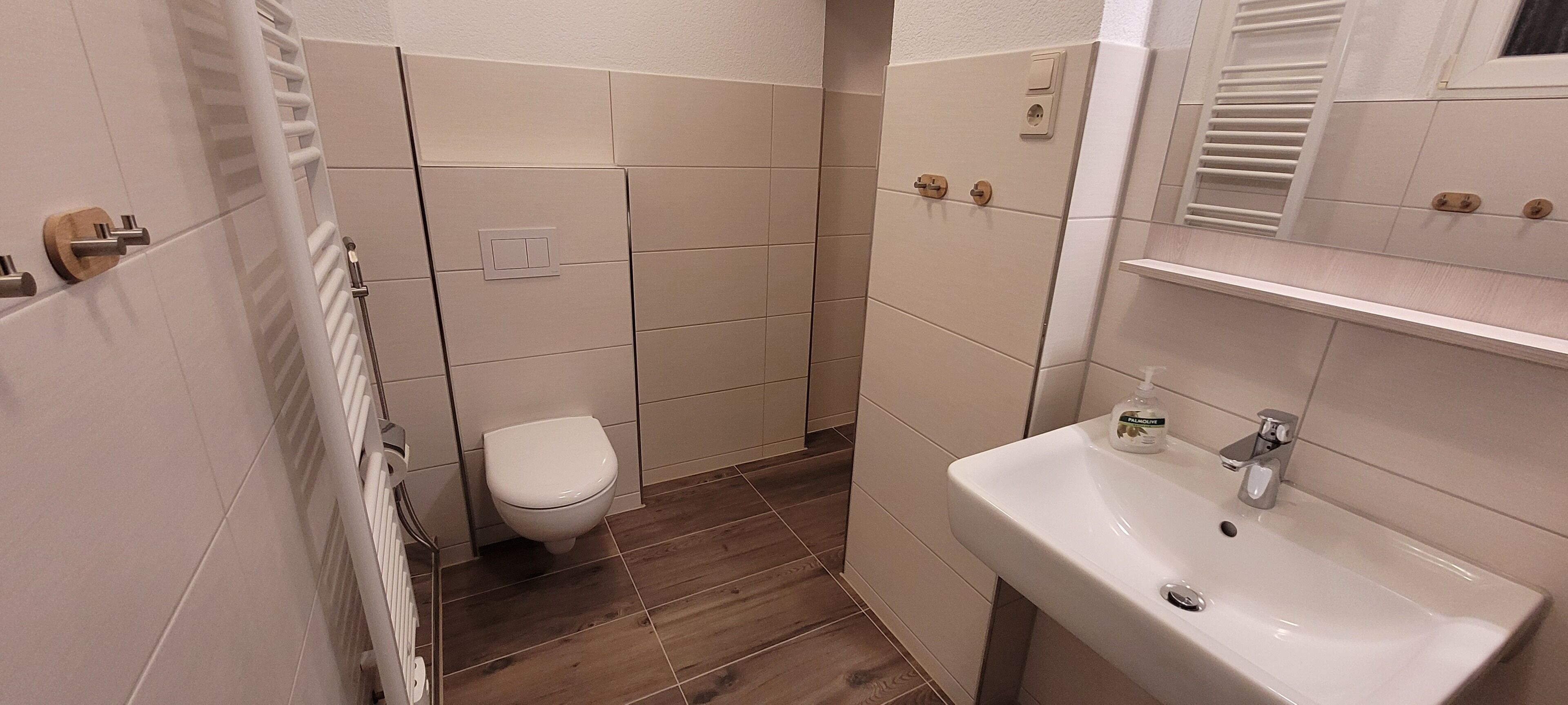 Ein Badezimmer mit Toilette, Waschbecken und Duschbereich.