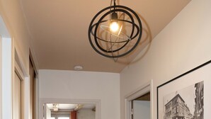 A hallway with wooden flooring, a ceiling light fixture, and a framed photograph on the wall. - Superb apartment in the city center (Tournus)