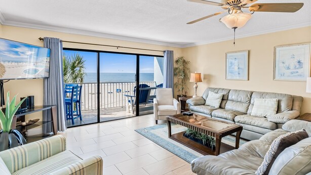 A spacious living room with a large sliding glass door leading to a balcony with a view of the ocean. - Sand Dollar 204: 2  BR, 2  BA Condominium in Indian Shores, Sleeps 6 (Indian Shores)