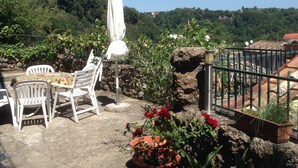 An outdoor patio with white chairs and a table, surrounded by potted plants and a white umbrella. - 2-storey vacation home with 2 large terraces and sensational views (Mazzano Romano)