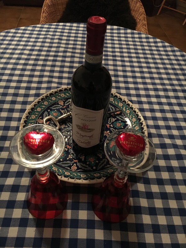 A bottle of wine on a checkered tablecloth with two decorative bottles on either side. - 2-storey vacation home with 2 large terraces and sensational views (Mazzano Romano)