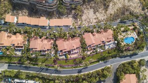 A resort with multiple buildings, a swimming pool, and a curved road.