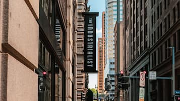 A street view with buildings, a sign for 'The Industrialist', and traffic signs.