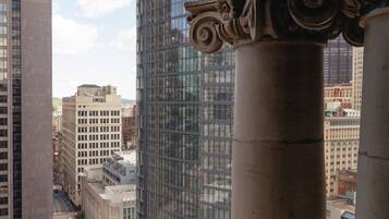 A view of a cityscape with a prominent glass building and classical columns.