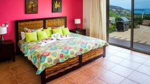 Una camera da letto con un letto grande, vista sull'esterno e un balcone con una griglia.
