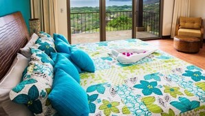 Una camera da letto con un letto, una sedia e un balcone con vista.