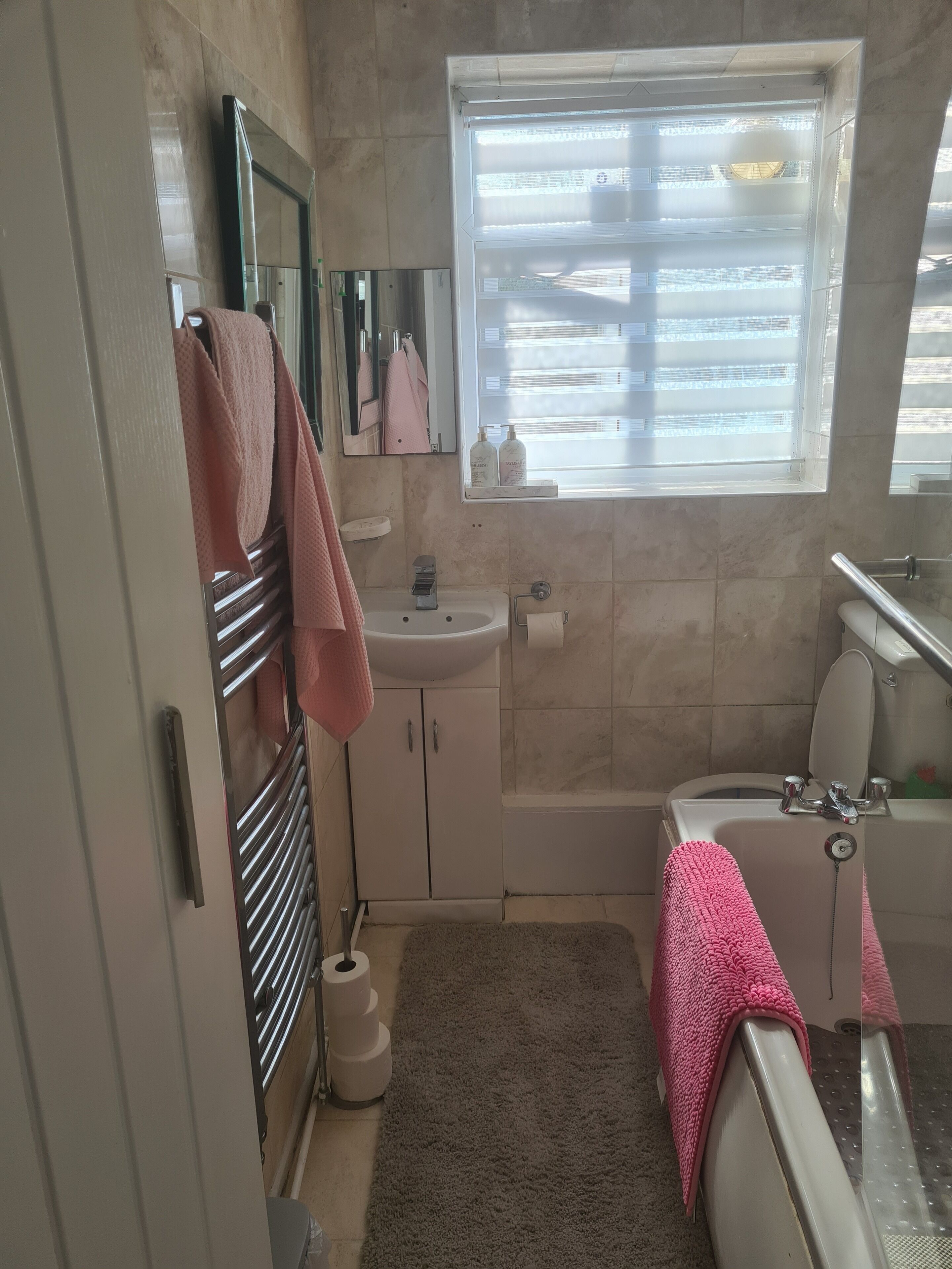 Een bad/douchecombinatie, een haardroger, handdoeken, toiletpapier