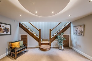 Ein modernes Interieur mit einer Holztreppe, einer Sitzbank und gerahmten Kunstwerken.