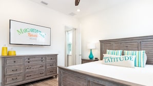 Un dormitorio con cama de madera, cómoda y televisor de pared mostrando 'Margaritaville Resort Orlando'.