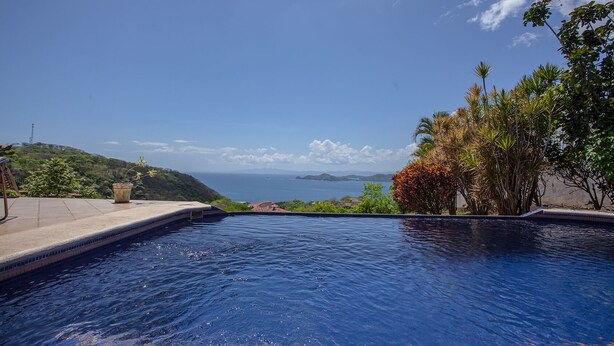 A swimming pool with a view of the ocean and hills. - Casa OM (Sardinal)