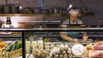 A chef preparing food in a kitchen with various ingredients and utensils visible.