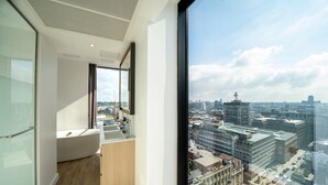 A modern hotel room with a large window, a bathtub, and a view of the cityscape. - INNSiDE by Meliá Liverpool (Liverpool)