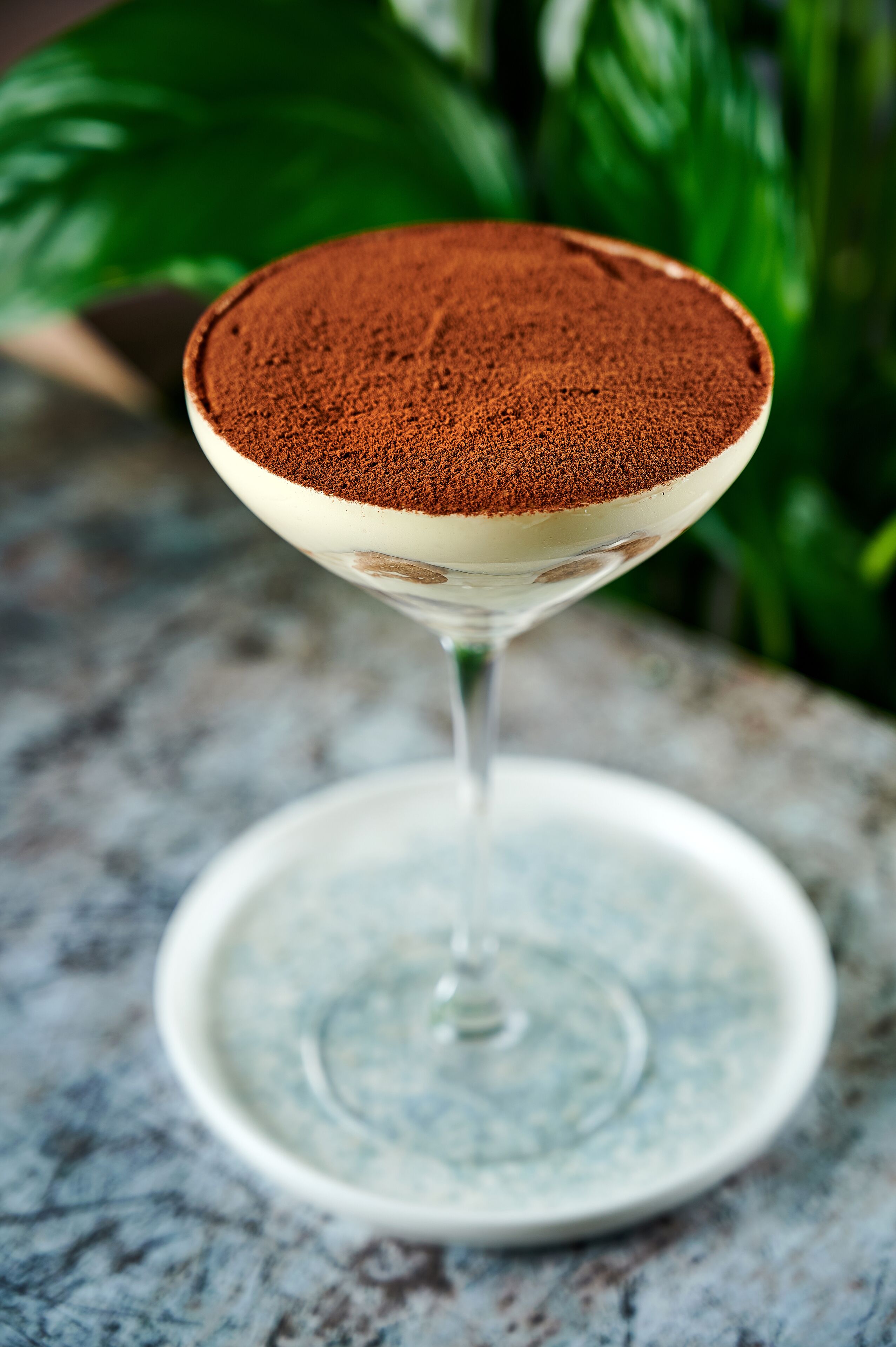 Una copa de martini con un postre sobre una superficie de mármol.