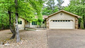 Ein zweistöckiges Haus mit Steinaußenwand, einer Garage und einer überdachten Veranda.
