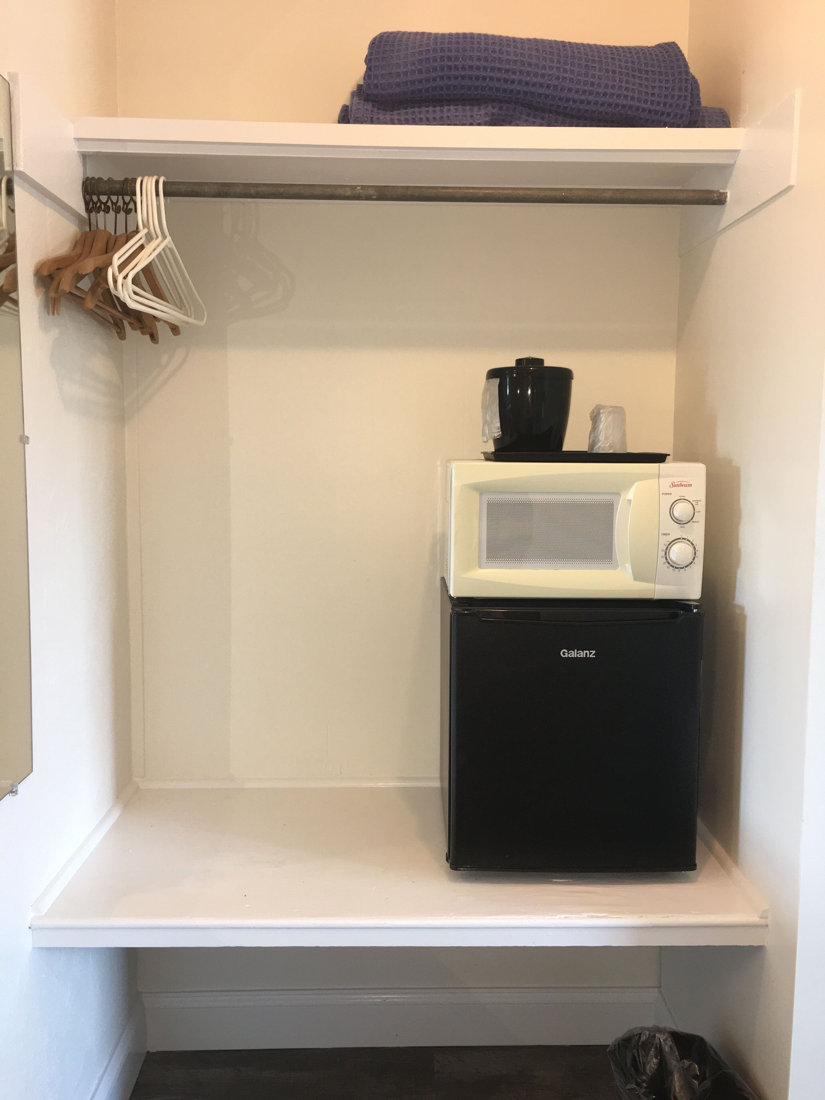 A compact kitchenette with a microwave and a small refrigerator.