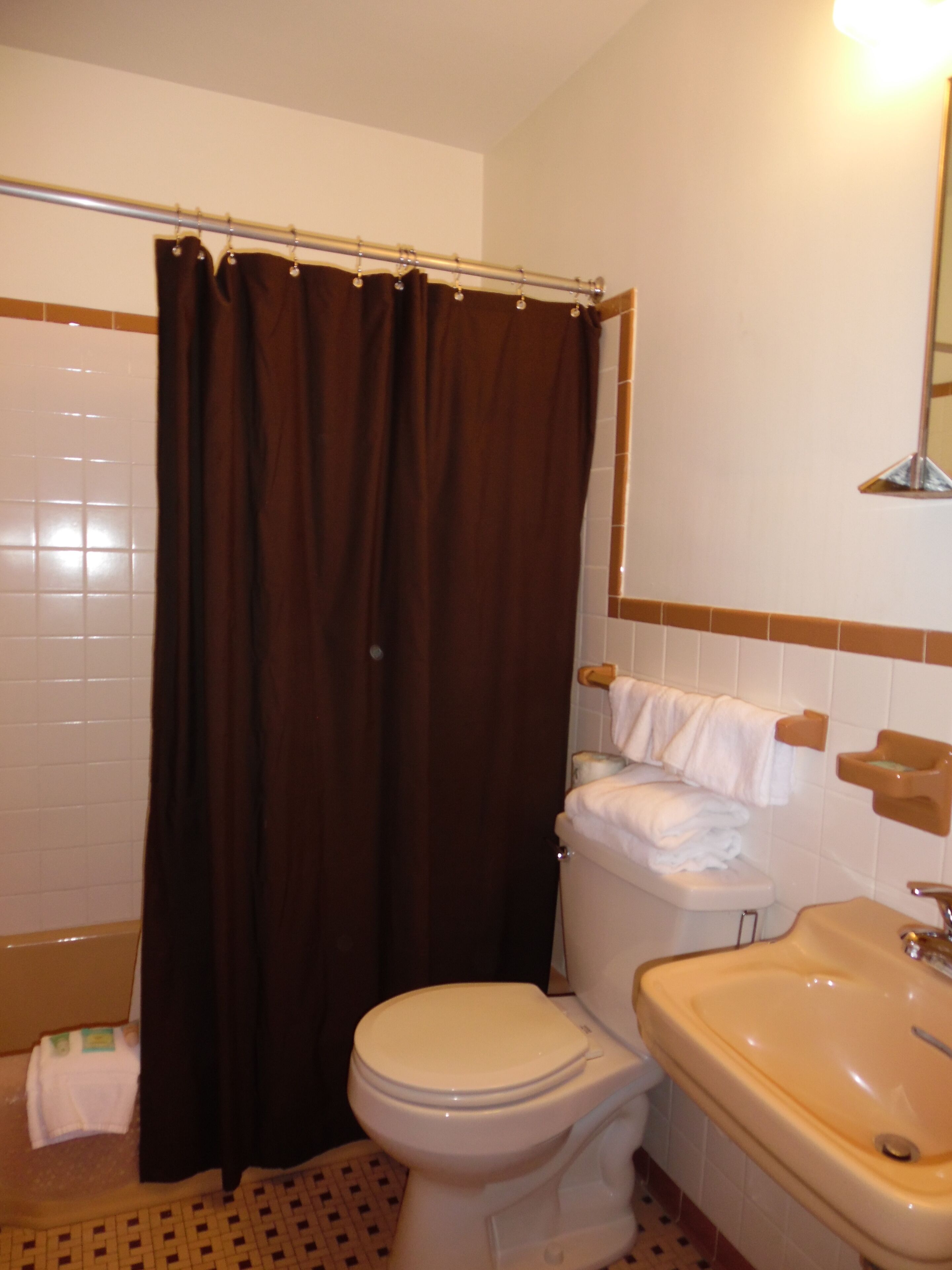 A bathroom with a toilet, a sink, and a shower curtain.