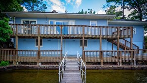 A two-story building with a wooden deck and a staircase leading to the upper level. - 13397 - 17 Aldaya Lane (Hot Springs)