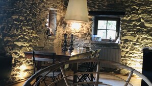 A rustic stone interior with a wooden dining table, chairs, and a hanging lamp. - STONE CHALET 6 pers.  ORELLE - SKI VAL THORENS + hiking/m.biking (Orelle)