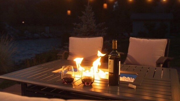 A table with a bottle and glasses, lit by a fire, under string lights. - Villa On The Boulevard, Redstone's Hidden Gem (Redstone)