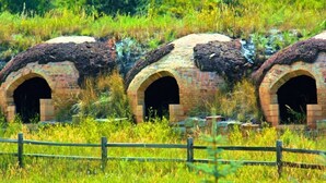 Three brick structures with arched openings, surrounded by grass and a wooden fence. - Villa On The Boulevard, Redstone's Hidden Gem (Redstone)