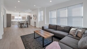 A spacious living room with a grey sofa, a wooden coffee table, and a patterned rug. - Paradise Cove  (Long Beach)