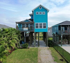 A two-story building with a blue exterior, a balcony, and a sign indicating it is a restaurant. - Modern Galveston Beach House! Short Walk to No-Cars Beach. Middle of West End (Galveston)