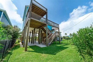 A modern multi-level house with a wooden deck and stairs leading to a balcony. - Modern Galveston Beach House! Short Walk to No-Cars Beach. Middle of West End (Galveston)
