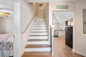 A staircase leading to a kitchen area with a sign reading 'BEACH HOUSE.' - Modern Galveston Beach House! Short Walk to No-Cars Beach. Middle of West End (Galveston)