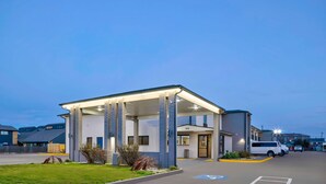 A modern building with a covered entrance, a parking area, and a clear sky. - Studio 6 Waco, TX - Downtown - Baylor (Waco)