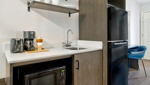 A compact kitchen with a microwave, coffee maker, and a sink. - Studio 6 Waco, TX - Downtown - Baylor (Waco)
