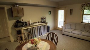 A compact living space with a kitchen area, dining table, and a sofa.