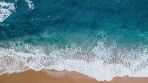 A beach with waves crashing onto the shore.