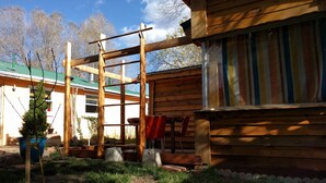 A wooden cabin with a metal scaffold structure, a small tree, and a bench. - Little Cottage in Flagstaff (Flagstaff)