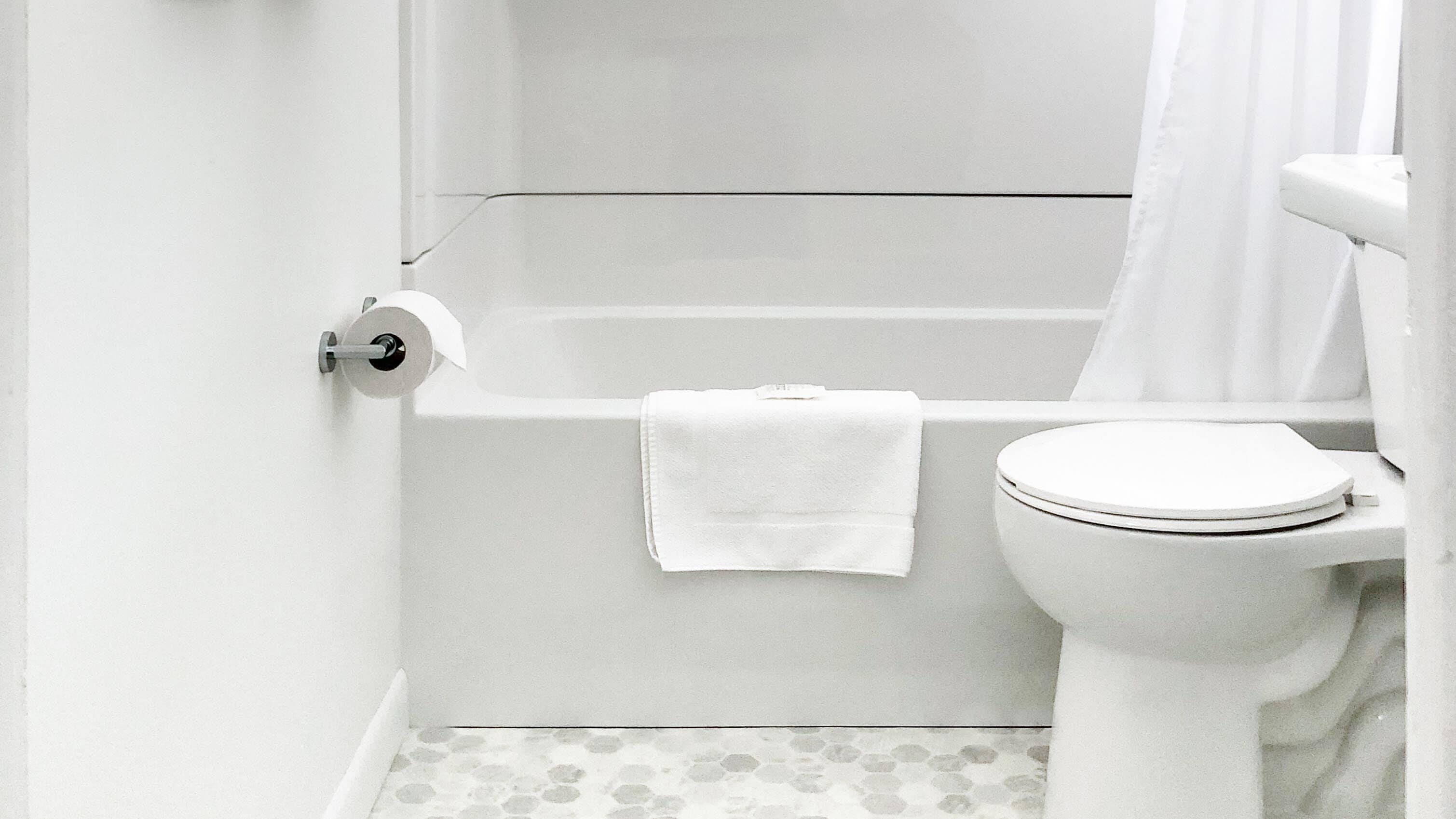 Un baño con inodoro, bañera y cortina de ducha.