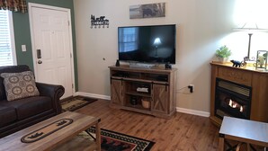 A living room with a television, a fireplace, a sofa, and a coffee table.