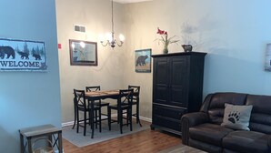 A living room with a dining table, chairs, a sofa, a cabinet, and a coffee table.