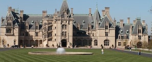 A large, historic building with a symmetrical facade, multiple chimneys, and a central entrance.