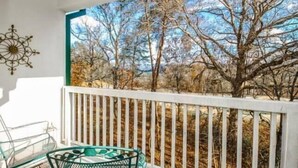 A balcony with a white railing, a glass table, and chairs. - 1501 Golf View Towers Southern Comfort (Pigeon Forge)