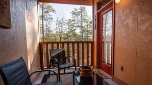 A balcony with two chairs, a small table, and a welcome basket. - 3211 Golf View Hillcrest Cordelia's Mtn View (Pigeon Forge)