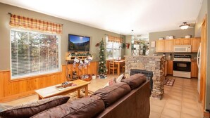 A cozy living room with a fireplace, wooden furniture, and a Christmas tree. - 3211 Golf View Hillcrest Cordelia's Mtn View (Pigeon Forge)