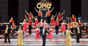 Een groep mensen op een podium, met een bord waarop staat 'Smoky Mountain Opry'.