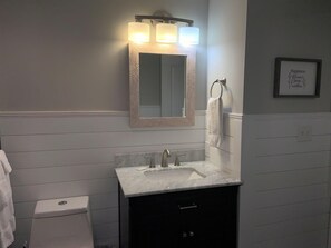 A bathroom with a white sink, a mirror with a patterned frame, and a towel ring. - 1404 Golf View Towers Smoky Mtn Bearadise (Pigeon Forge)
