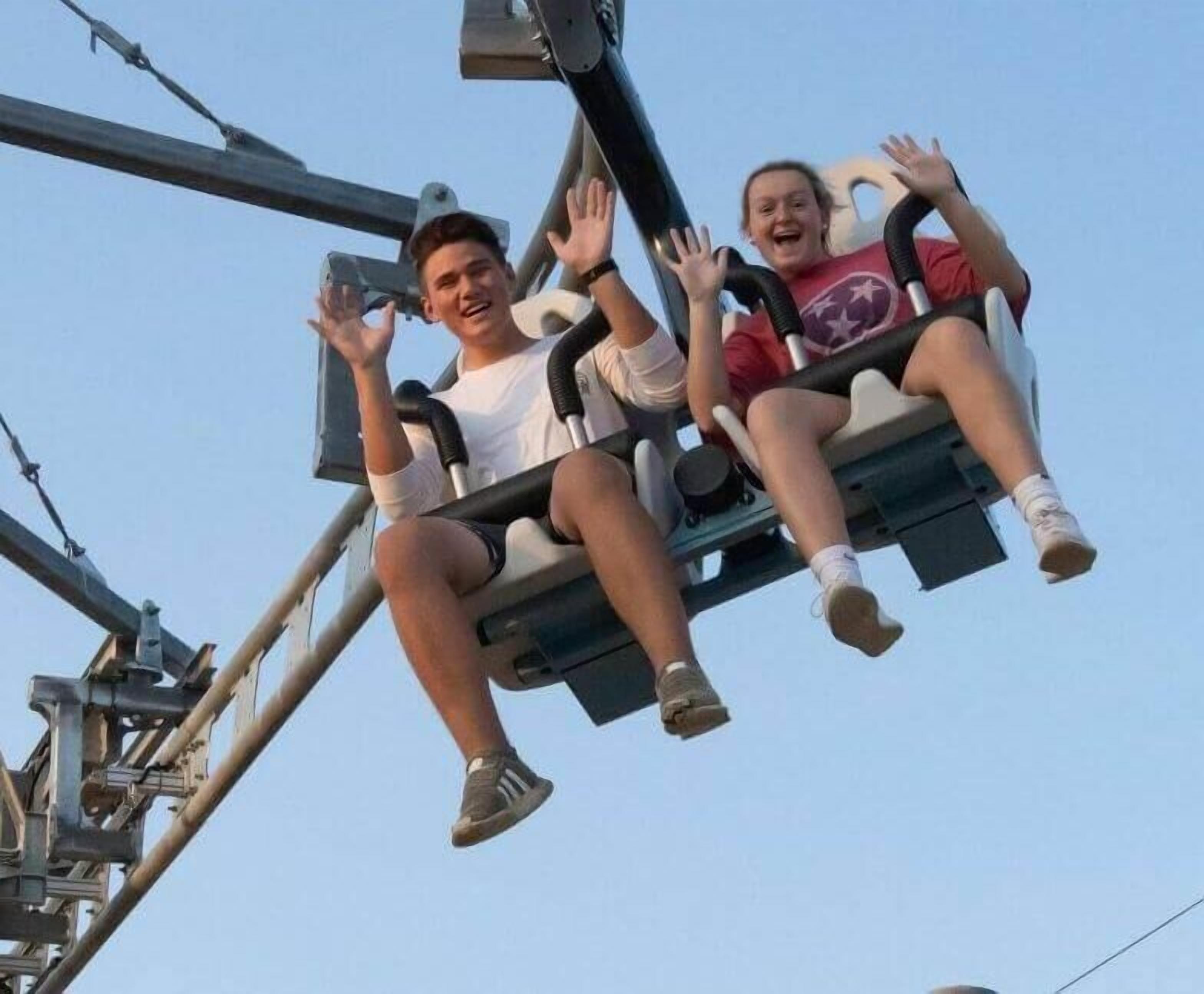 Deux personnes sur une balançoire dans un parc d’attractions.